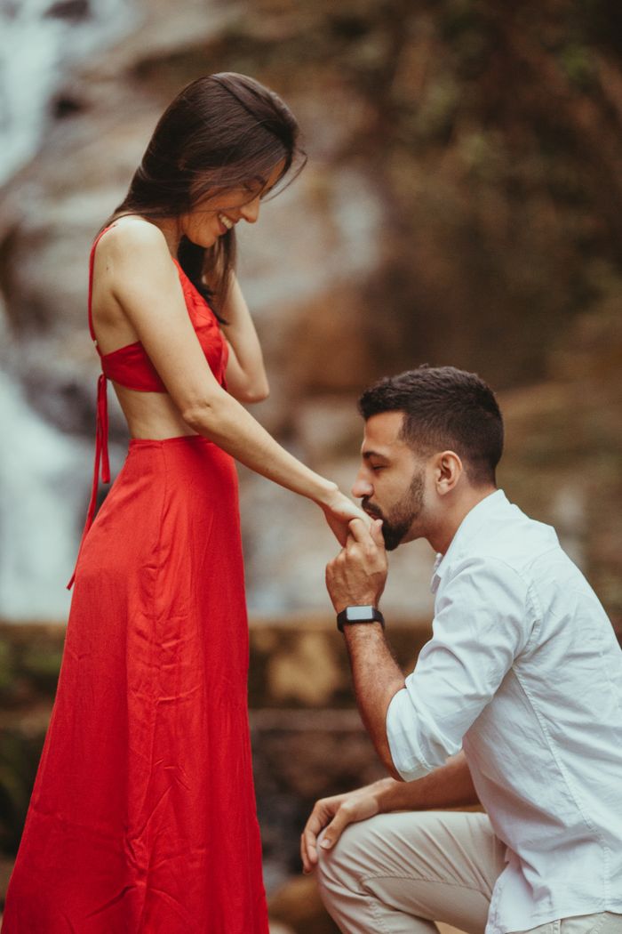 Couple sharing a romantic moment by a waterfall in summer.