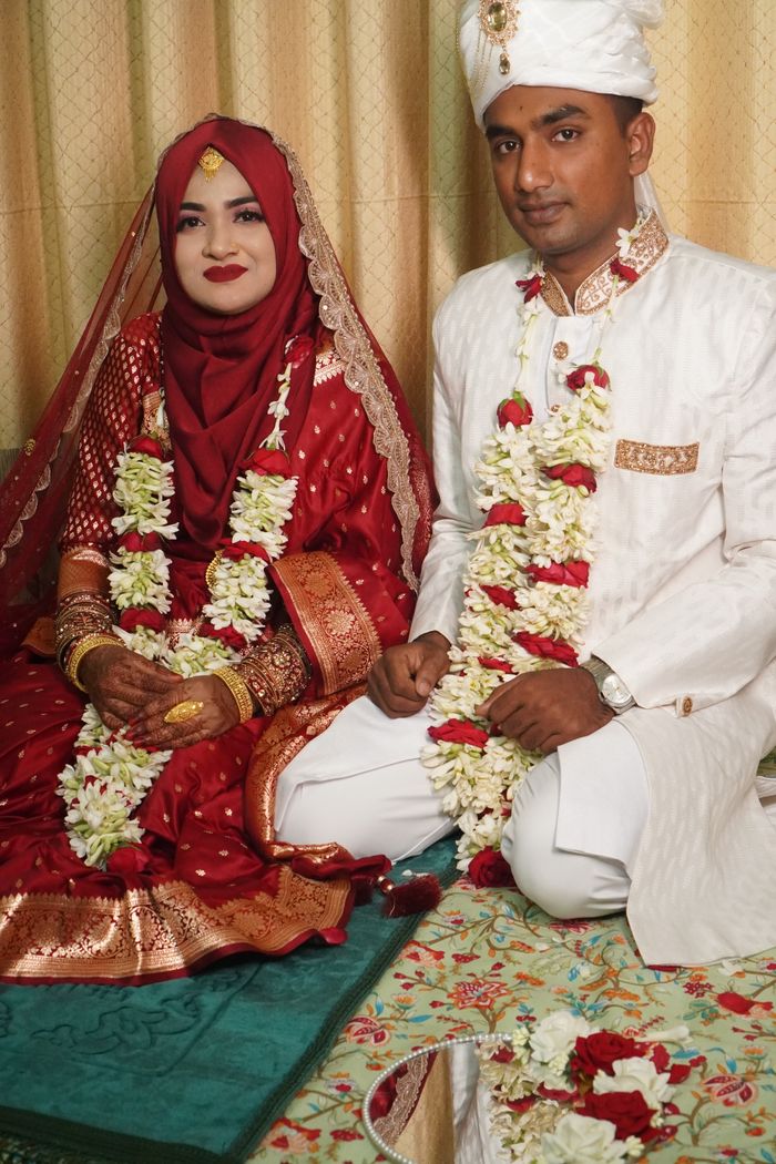 A beautifully adorned South Asian couple in traditional wedding attire at their ceremony, showcasing cultural elegance.