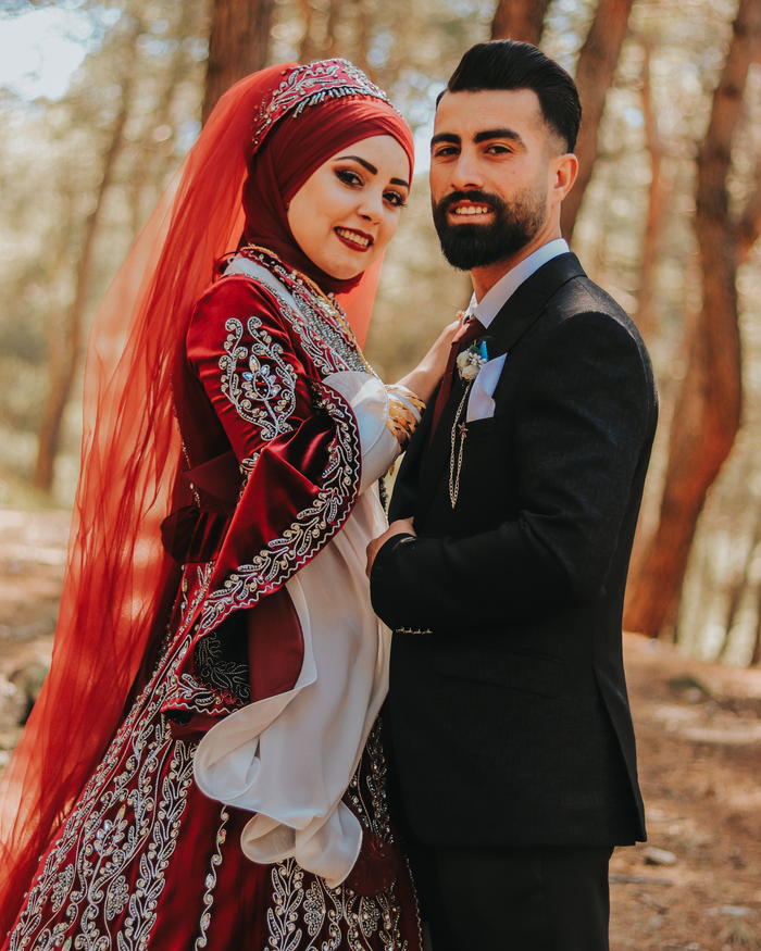 Beautiful outdoor photo of a Muslim couple in wedding attire, embracing joyfully.